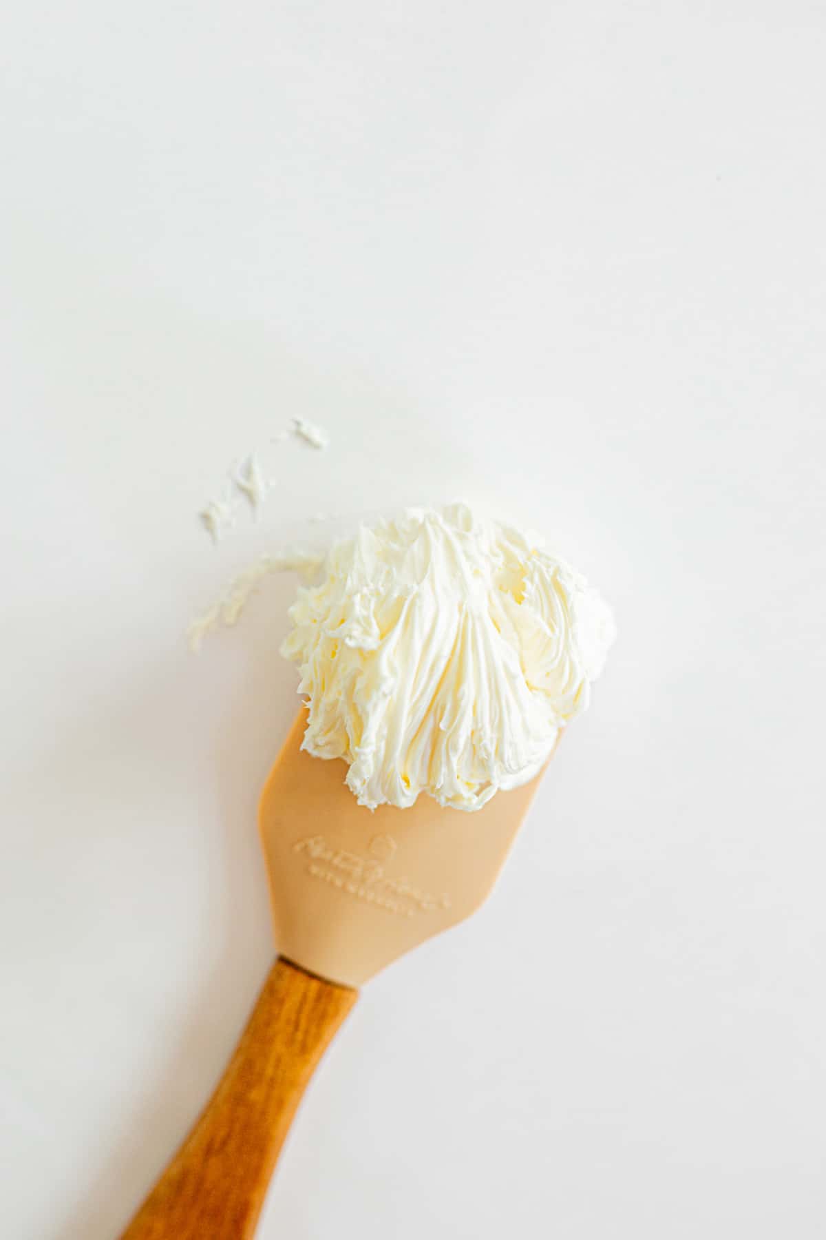 whipped butter on a tan rubber spatula.