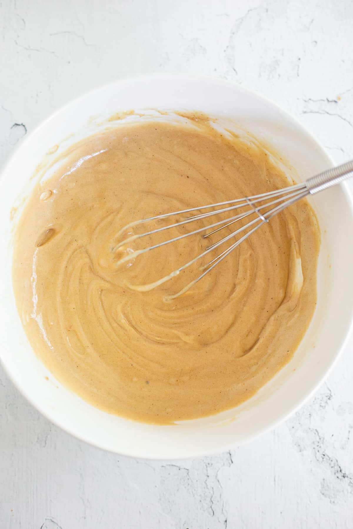 gluten free yellow cake batter in a white mixing bowl.