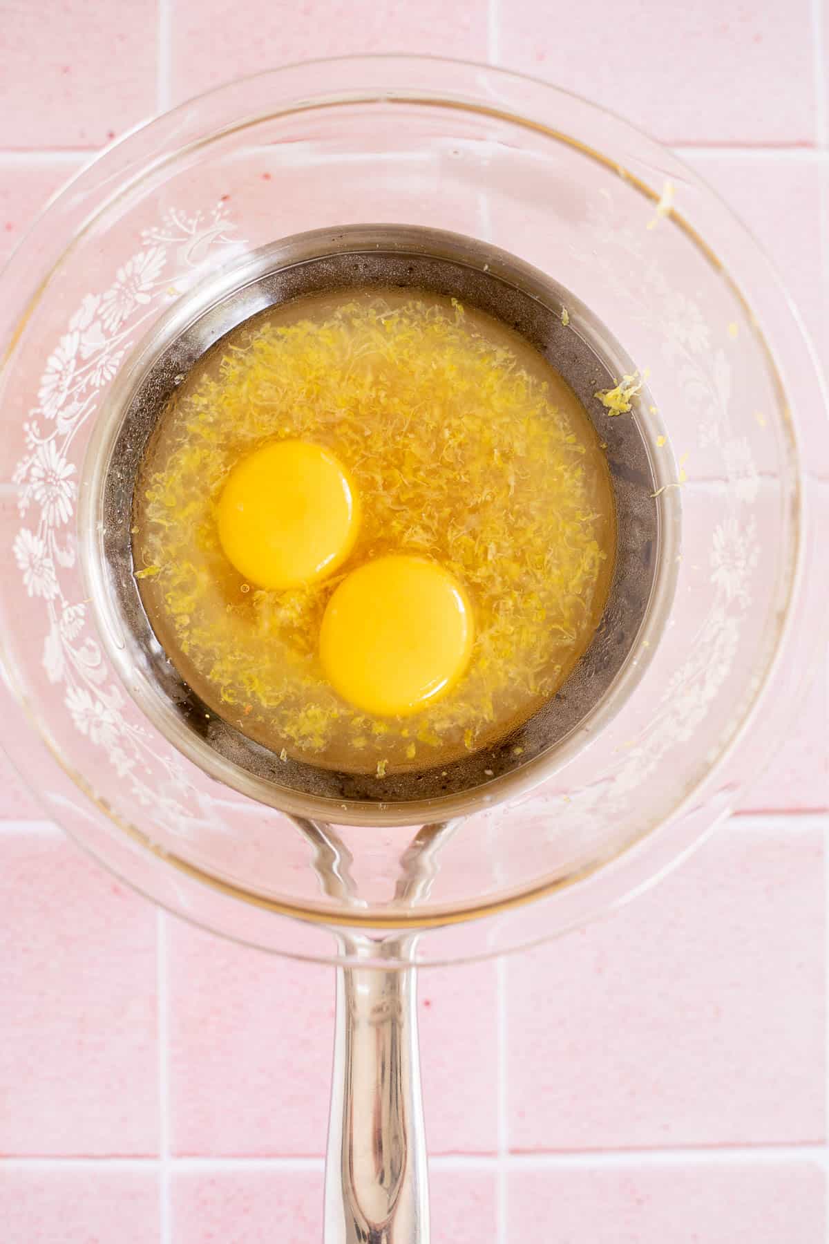 lemon juice, lemon zest, sugar, and egg yolks in a glass bowl of a double boiler.