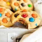 small batch M&M cookies in a silver tin with parchment paper.