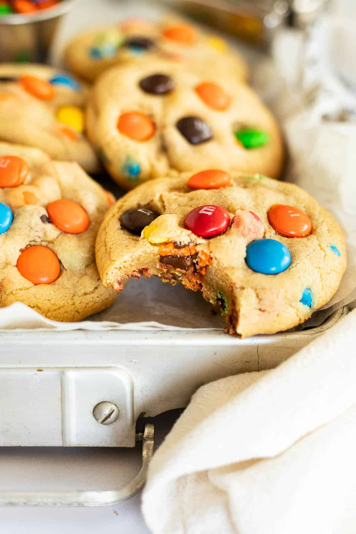 small batch M&M cookies in a silver tin with parchment paper.