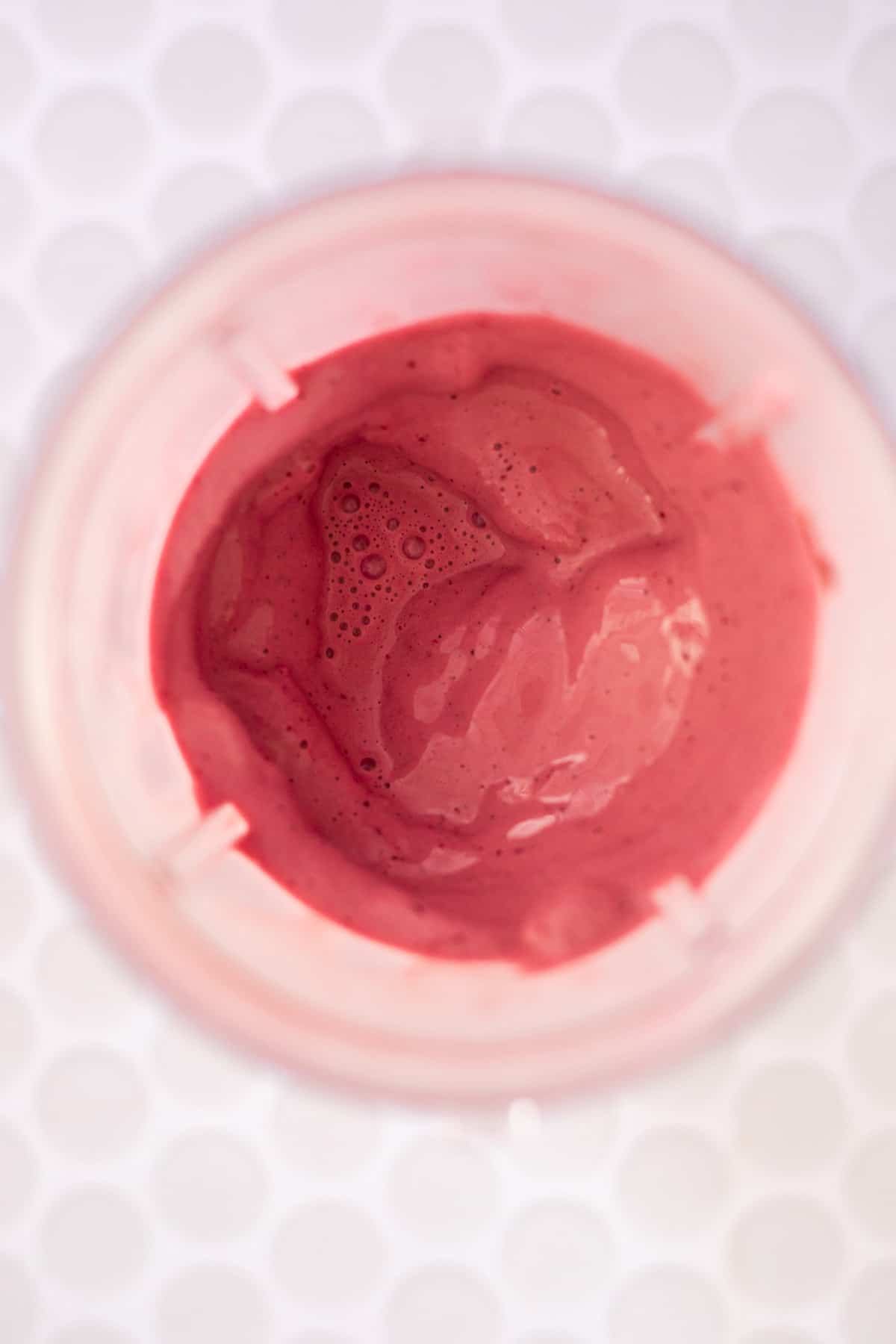 blended cherry milkshake in a blender cup.