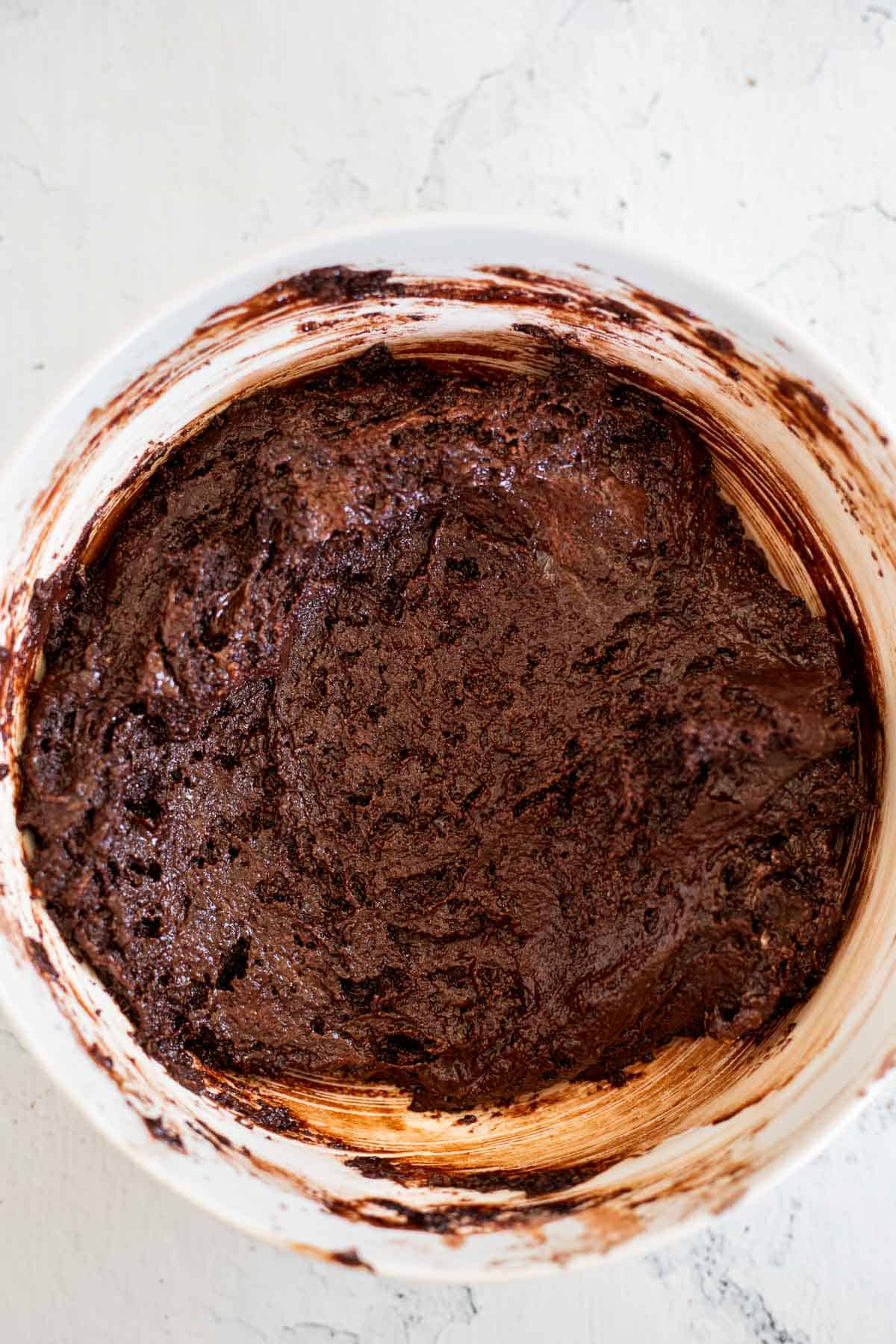 flour, cocoa powder, sugar, mixed with oil, and sour cream in a white bowl.