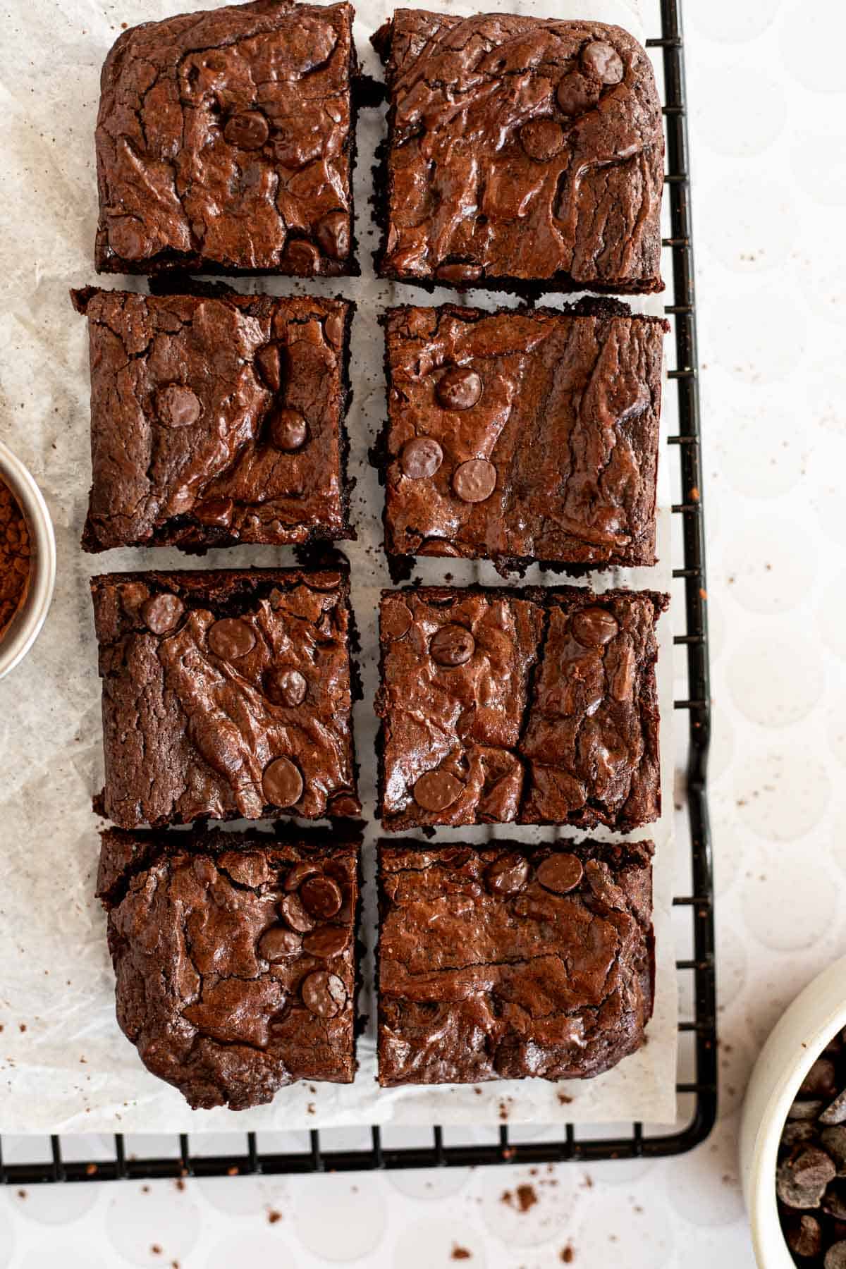 8 brownies cut into squares on parchment paper.