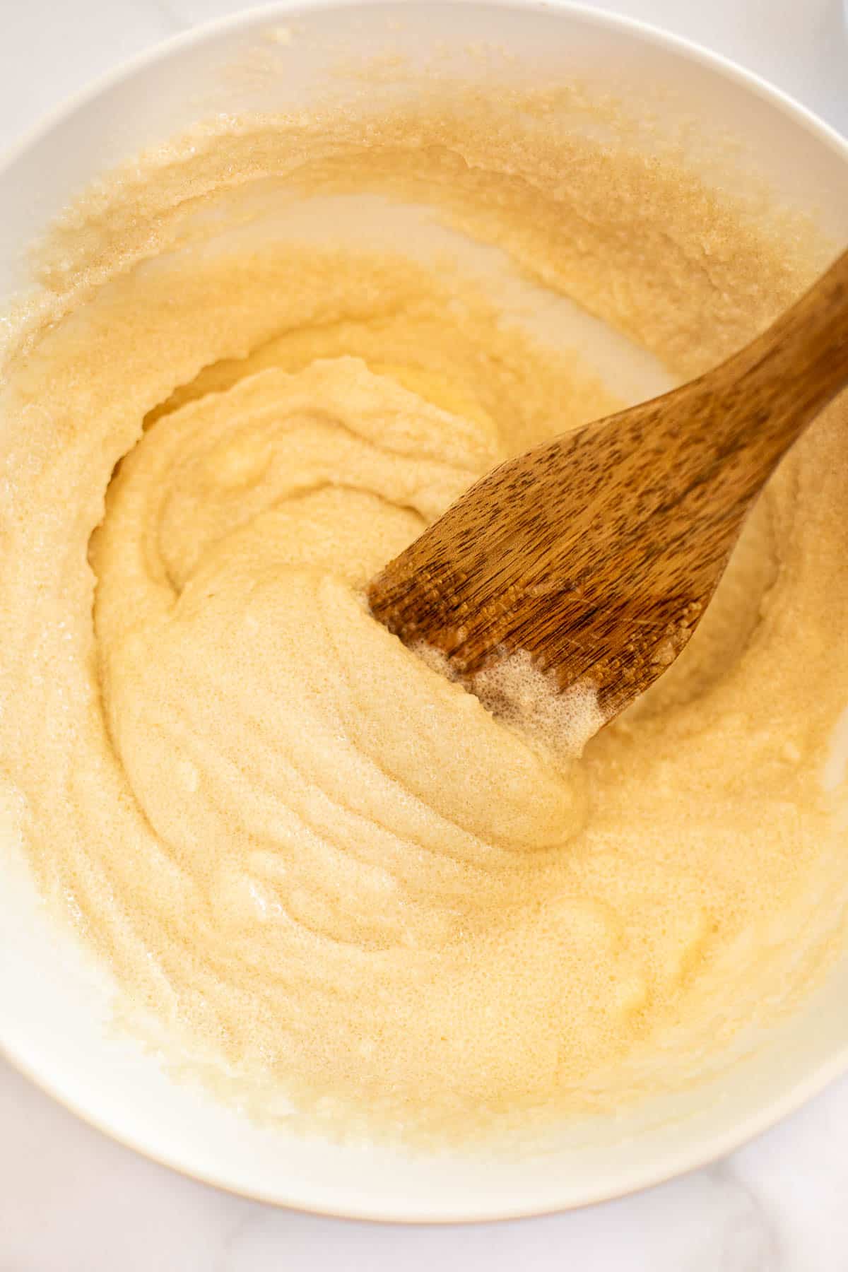 butter, oil, and sugar mixed together in a white bowl.