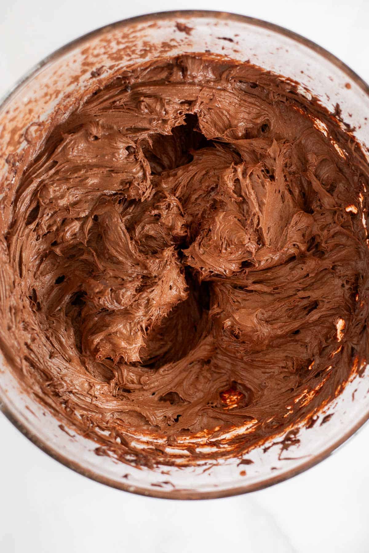 Fudgy chocolate frosting in a glass bowl.