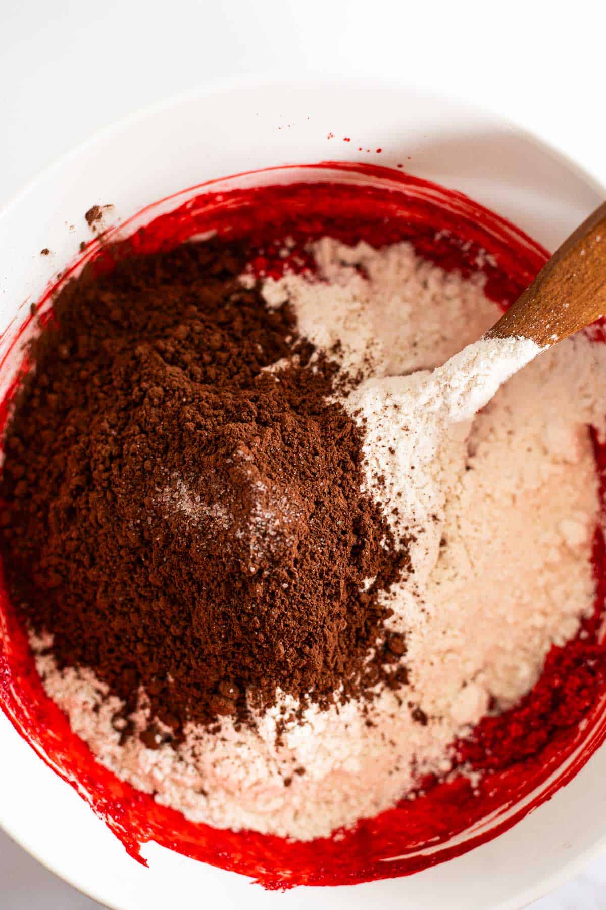 flour and cocoa powder with softened butter in a white bowl.
