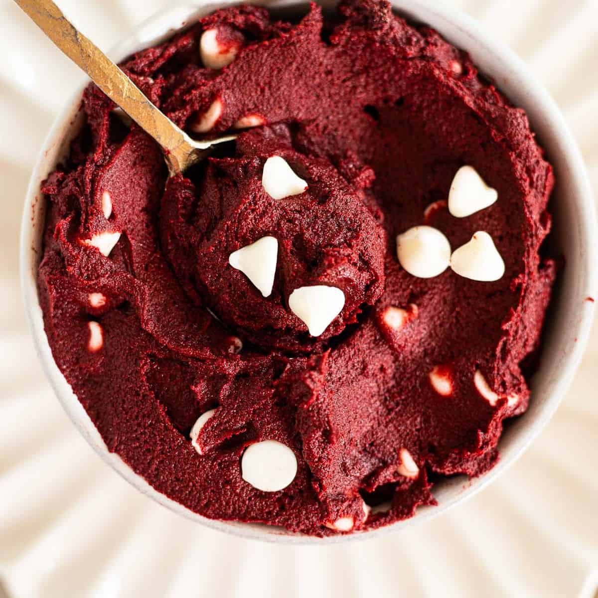 red velvet cookie dough with white chocolate chips in a white bowl.