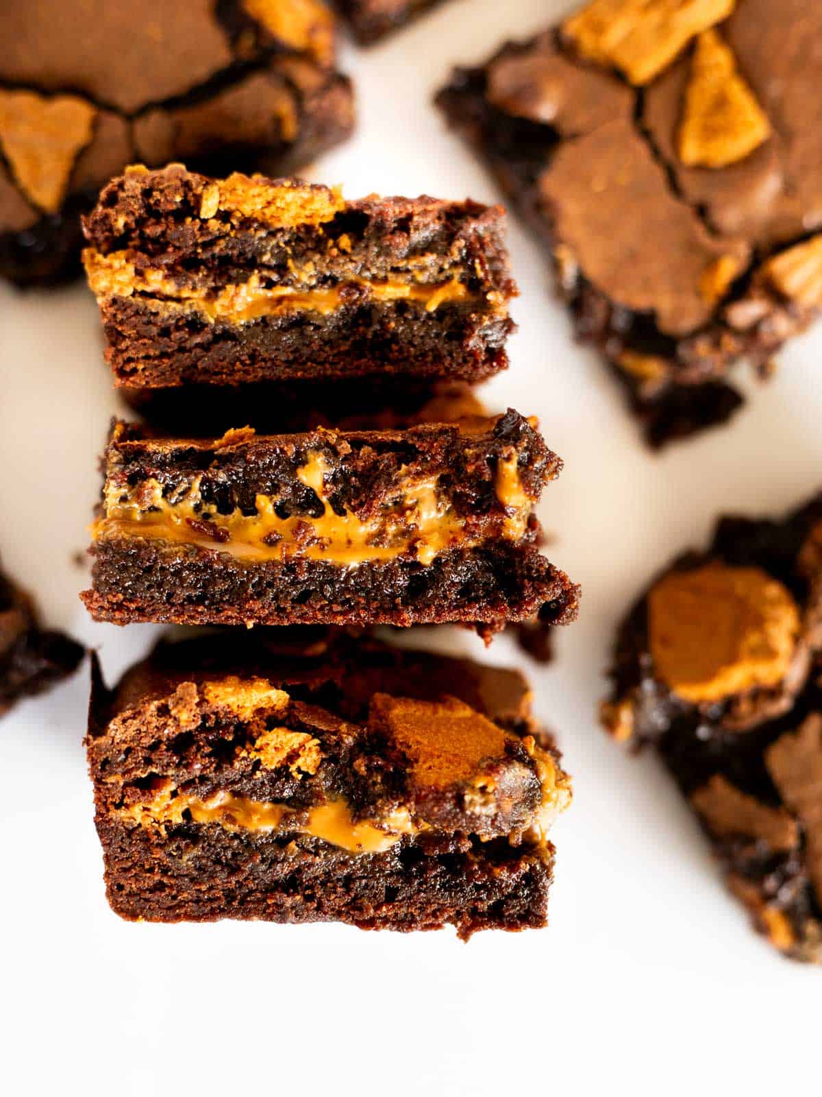 three brownies with cookie butter stacked on a white background.