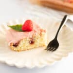 a slice of lemon raspberry sheet cake on a white plate with a black fork.
