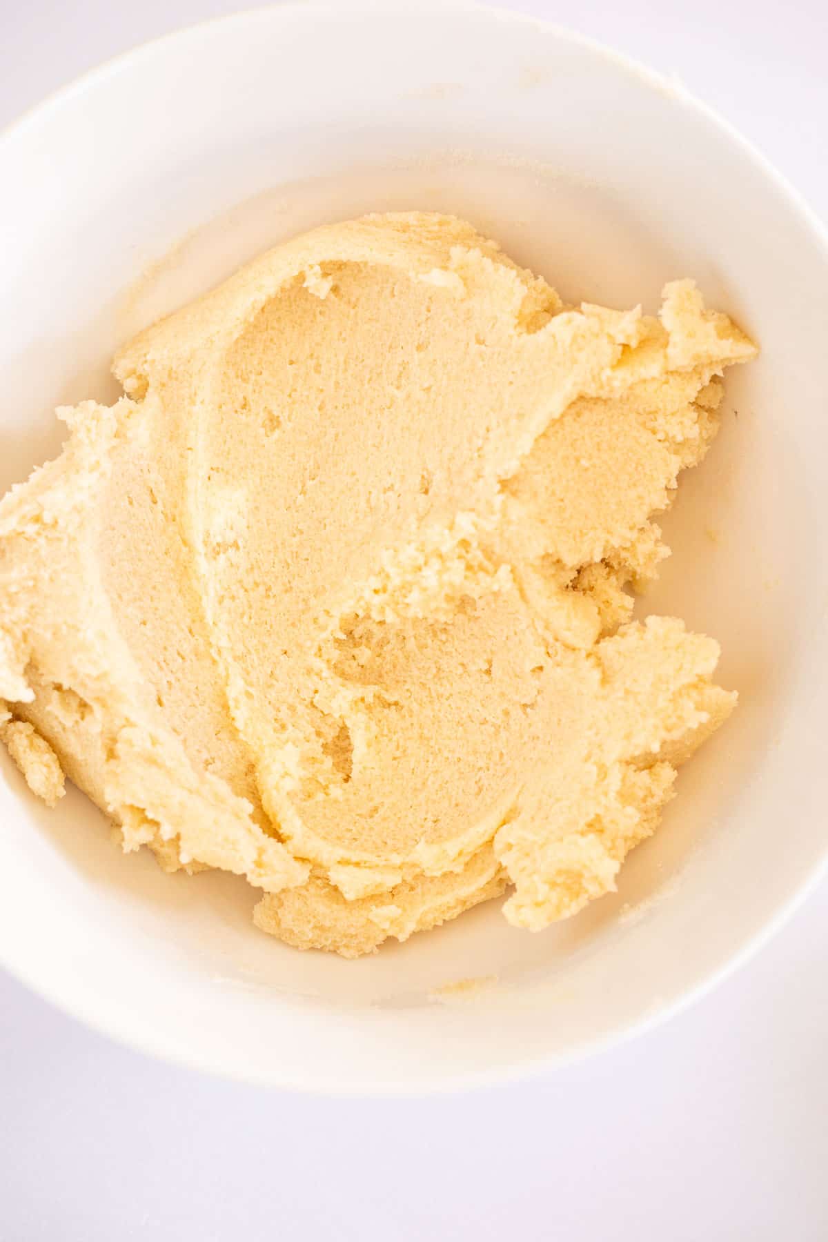 softened butter and sugar mixed in a white mixing bowl.