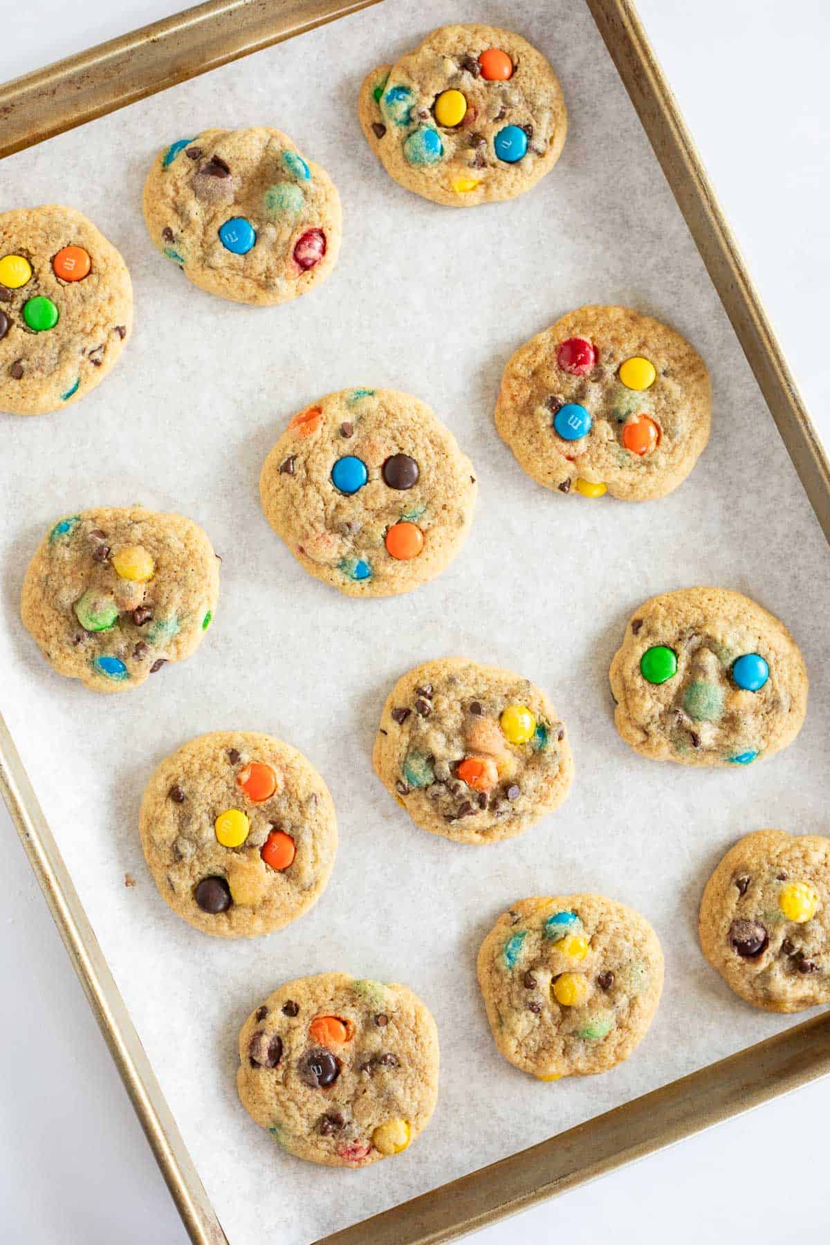 M&M cookie baked on a parchment lined baking sheet.