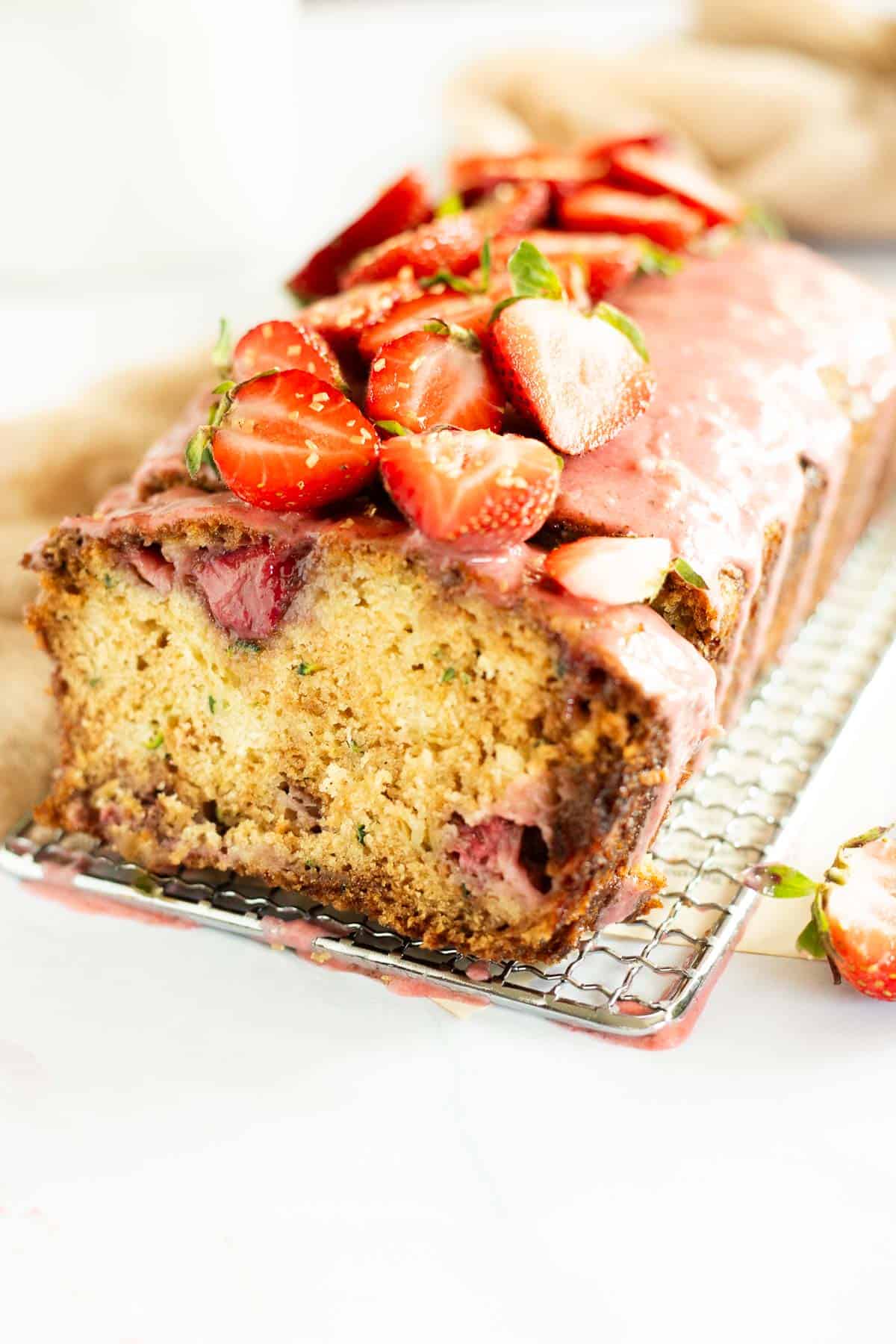 slice of zucchini bread with strawberries and a strawberry glaze.