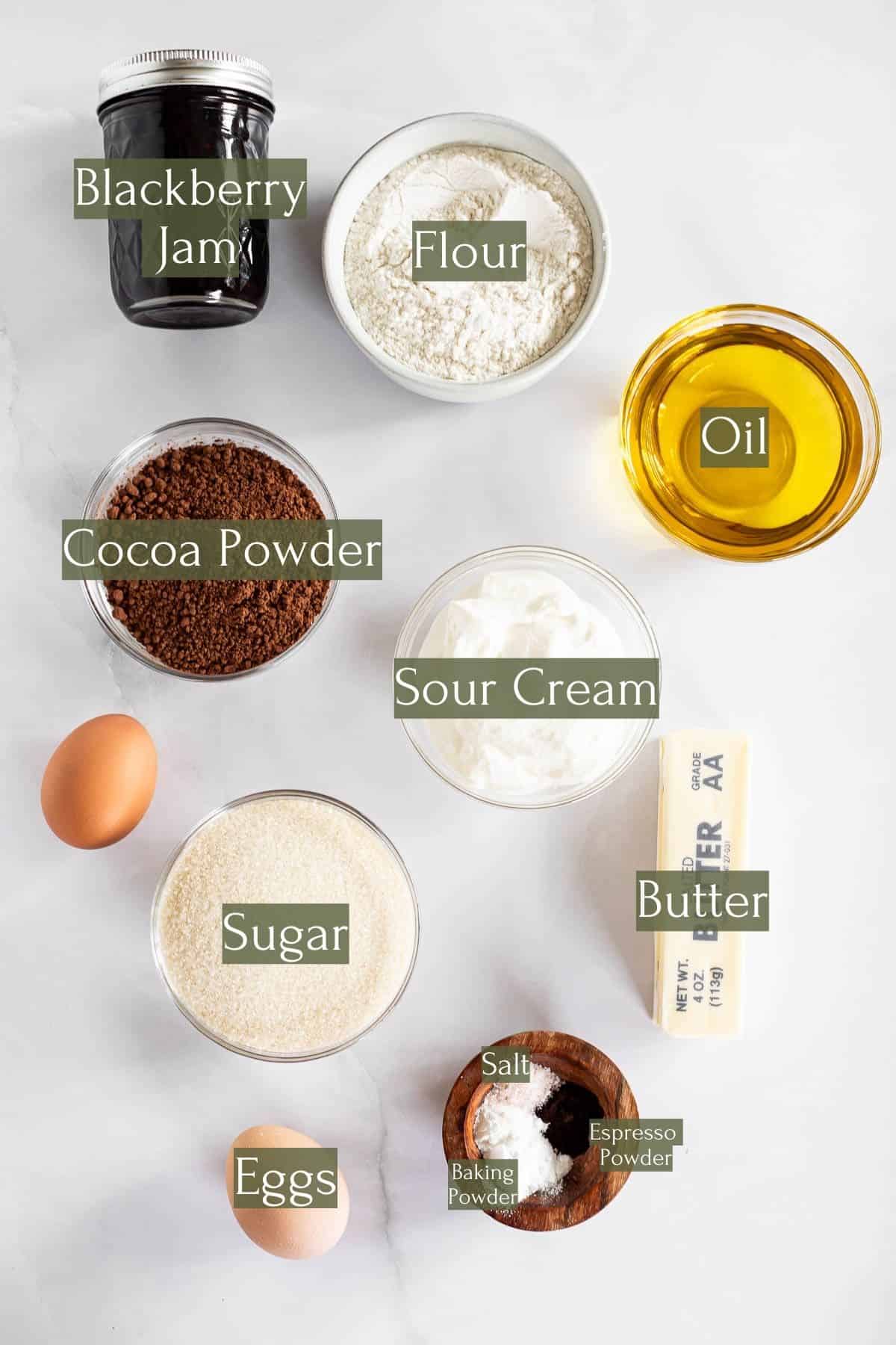 ingredients to make chocolate cupcakes with blackberries labeled with green text boxes.