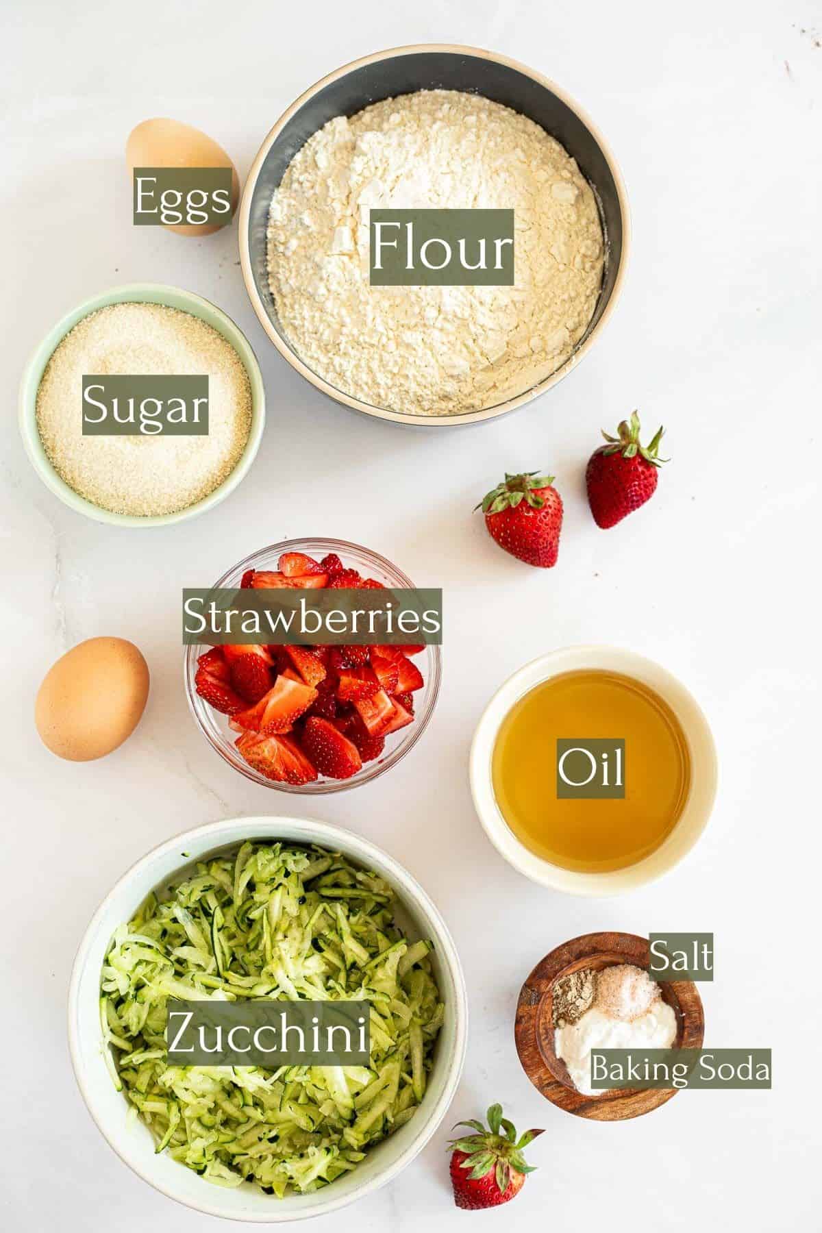ingredients to make zucchini bread with strawberries labeled with text.