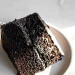 a slice of black velvet cake on a white plate.