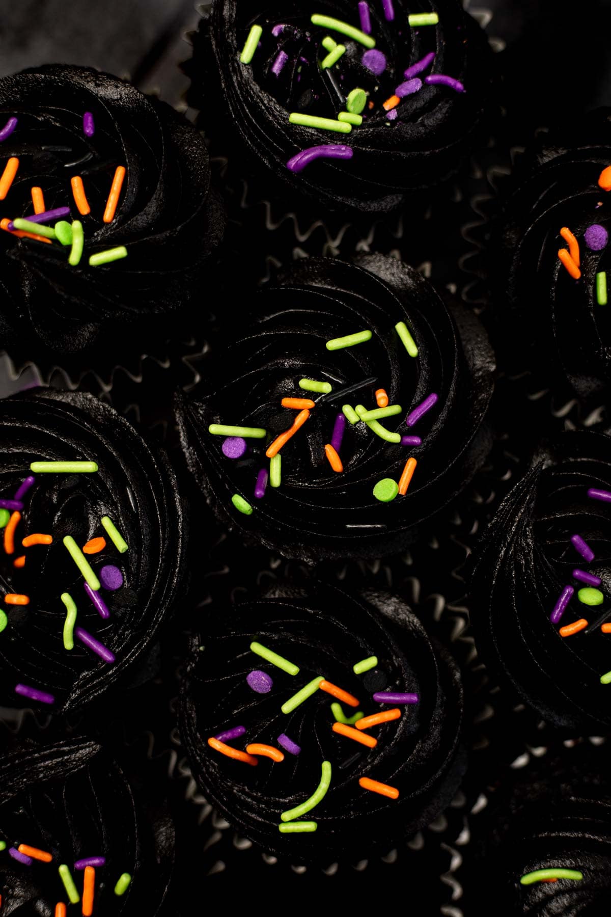 overhead photo of black velvet cupcakes with halloween sprinkles.