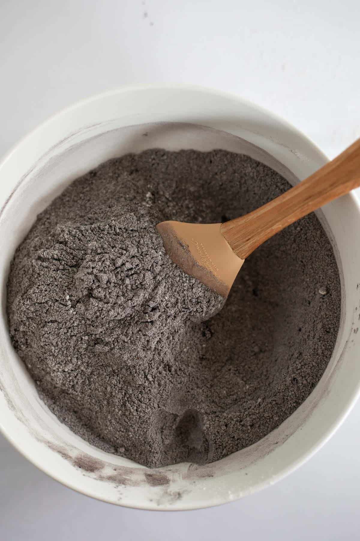 flour, black cocoa powder, and sugar mixed in a white mixing bowl.