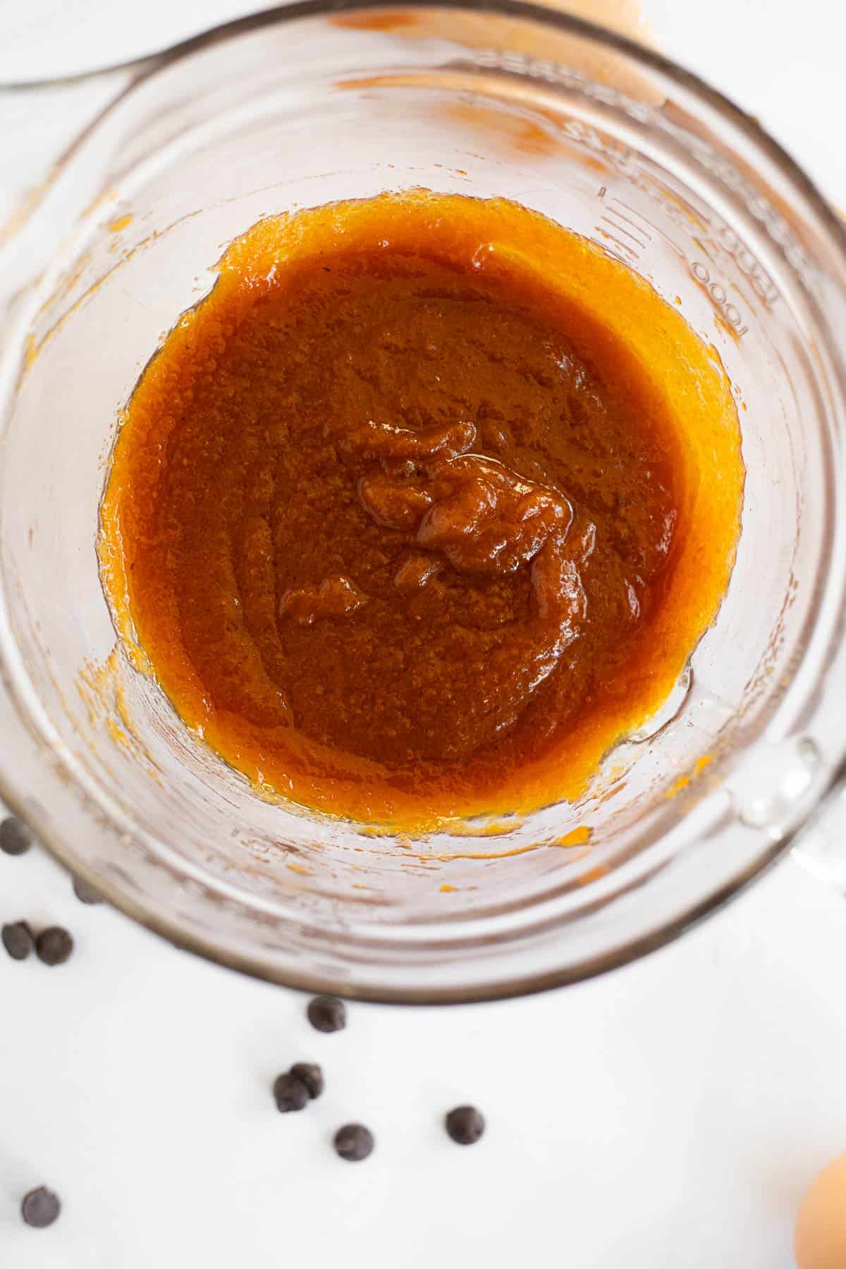 pumpkin puree and oil mixed in a glass bowl.