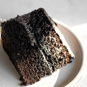 a slice of black velvet cake on a white plate.
