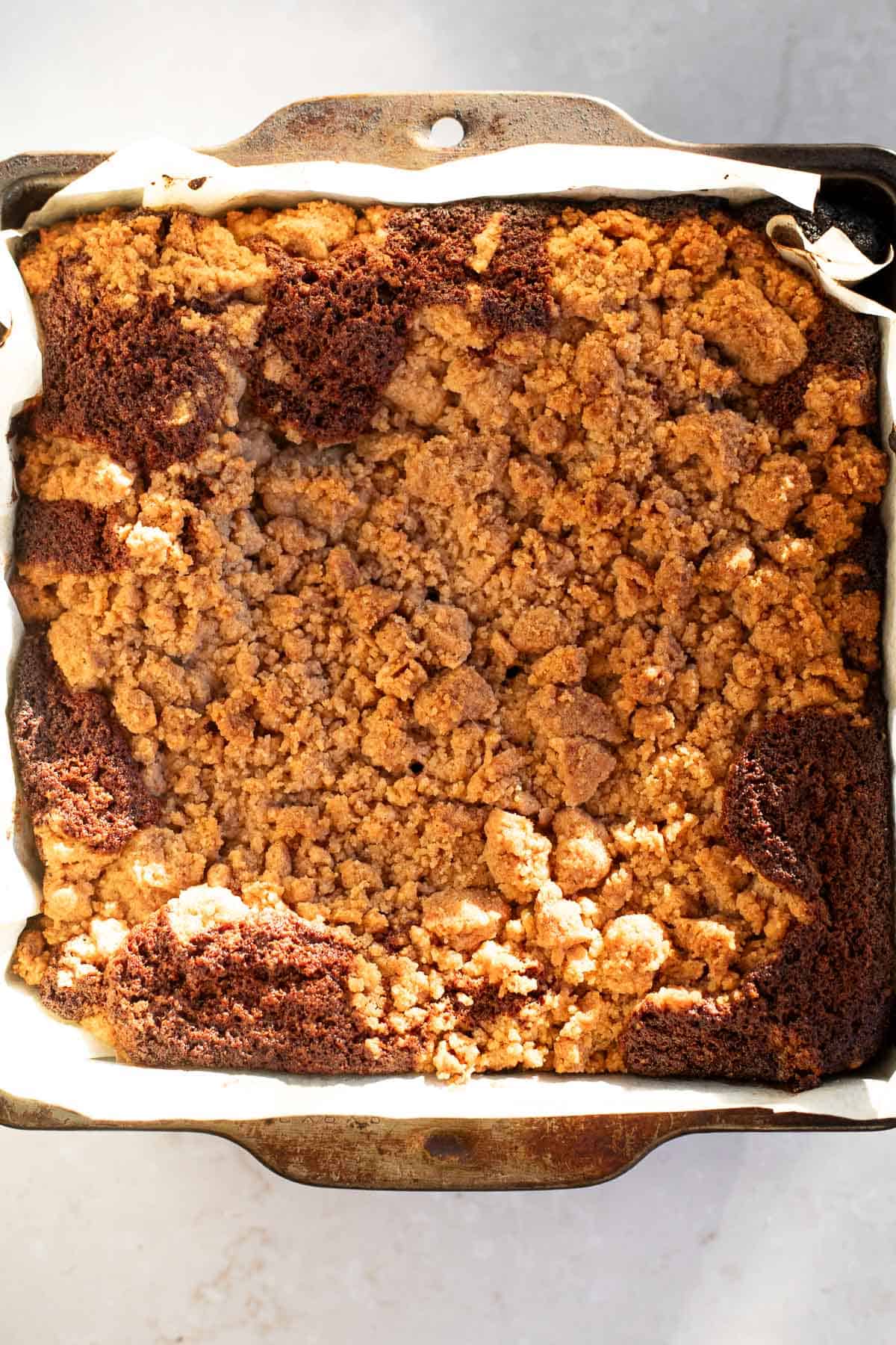 overhead photo of apple cider crumb cake baked in a metal pan.