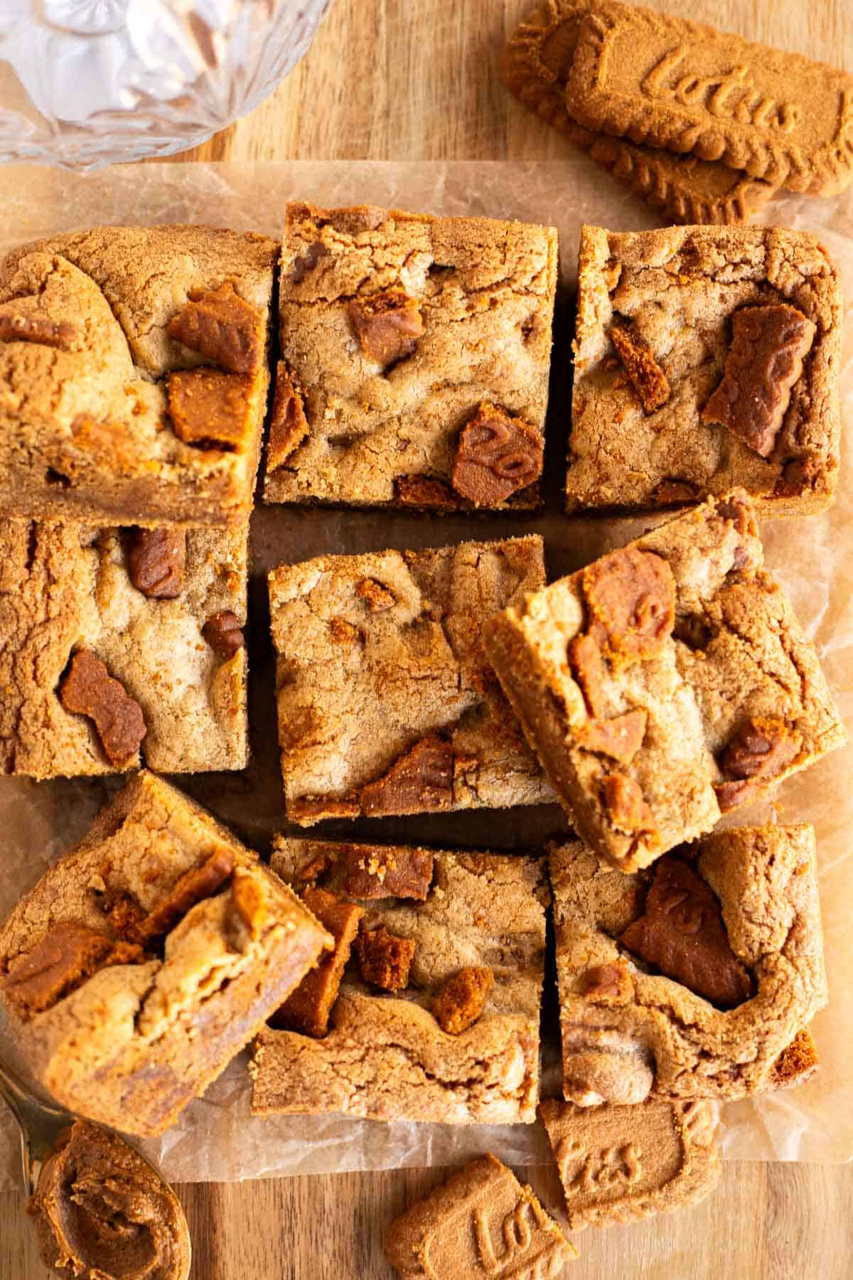 overhead photo of biscoff cookie bars cut into squares on parchment paper.