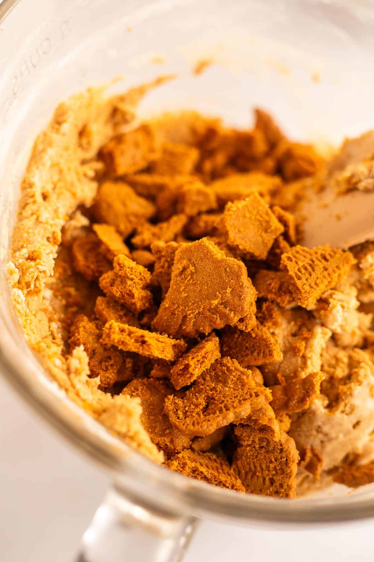 crushed biscoff cookies in a glass bowl of cookie butter cookie dough.