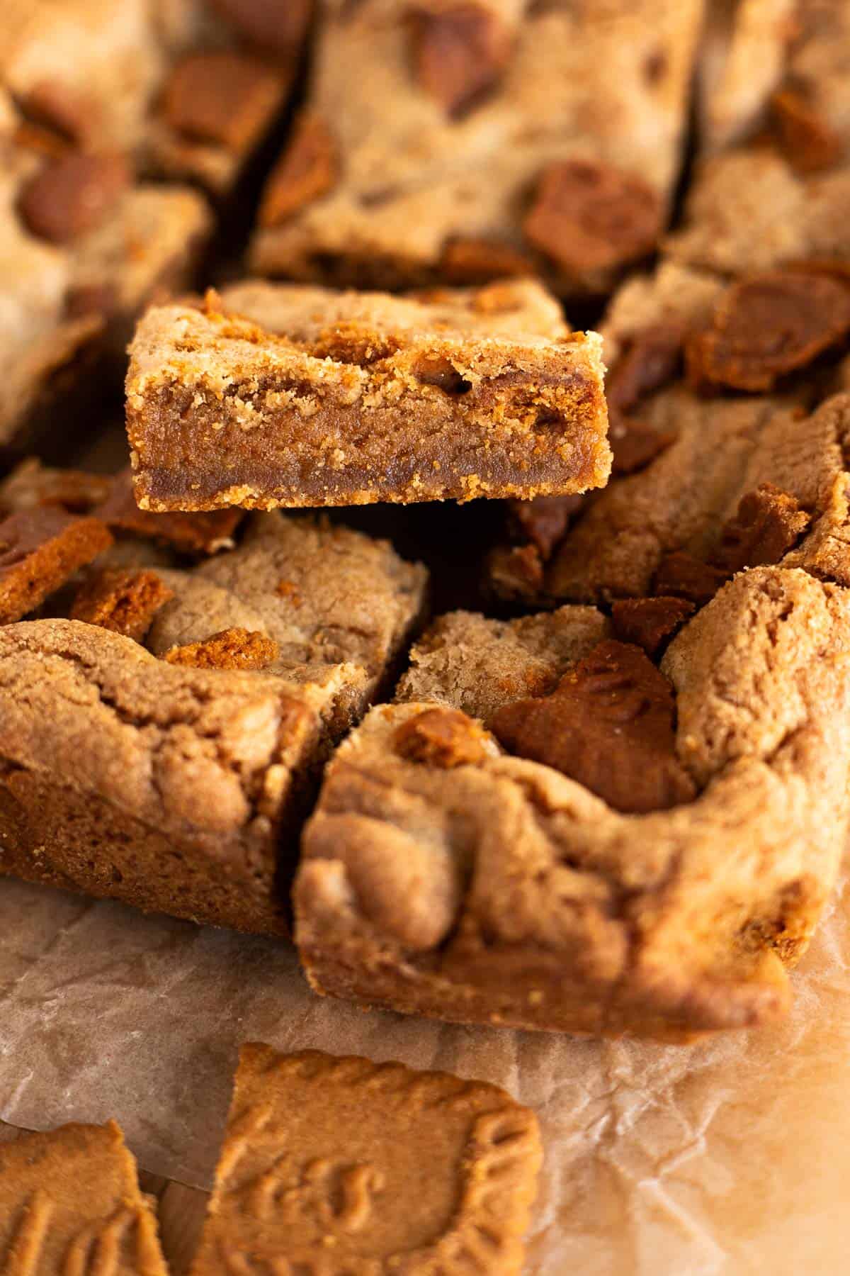 Biscoff cookie bars cut into squares on brown parchment paper.
