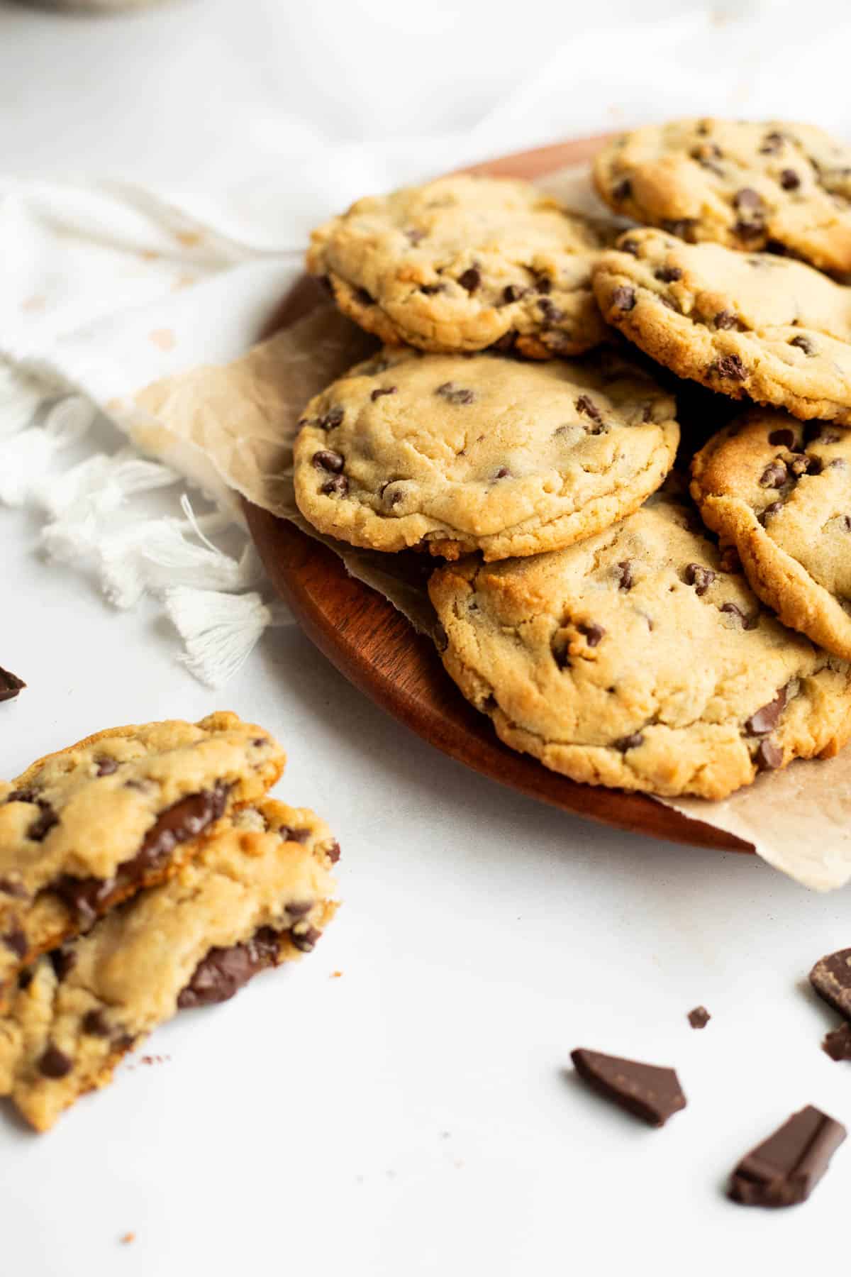 chocolate filled cookies on a wooden tray with one split in half on the side.