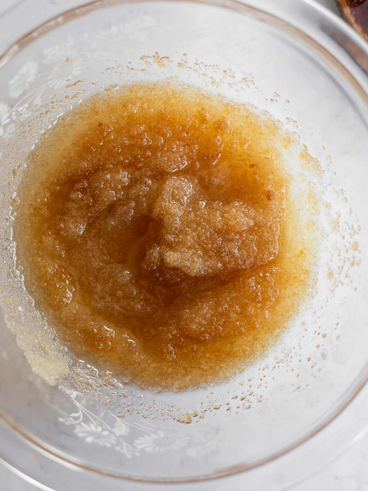 oil and sugar mixed together in a glass bowl.