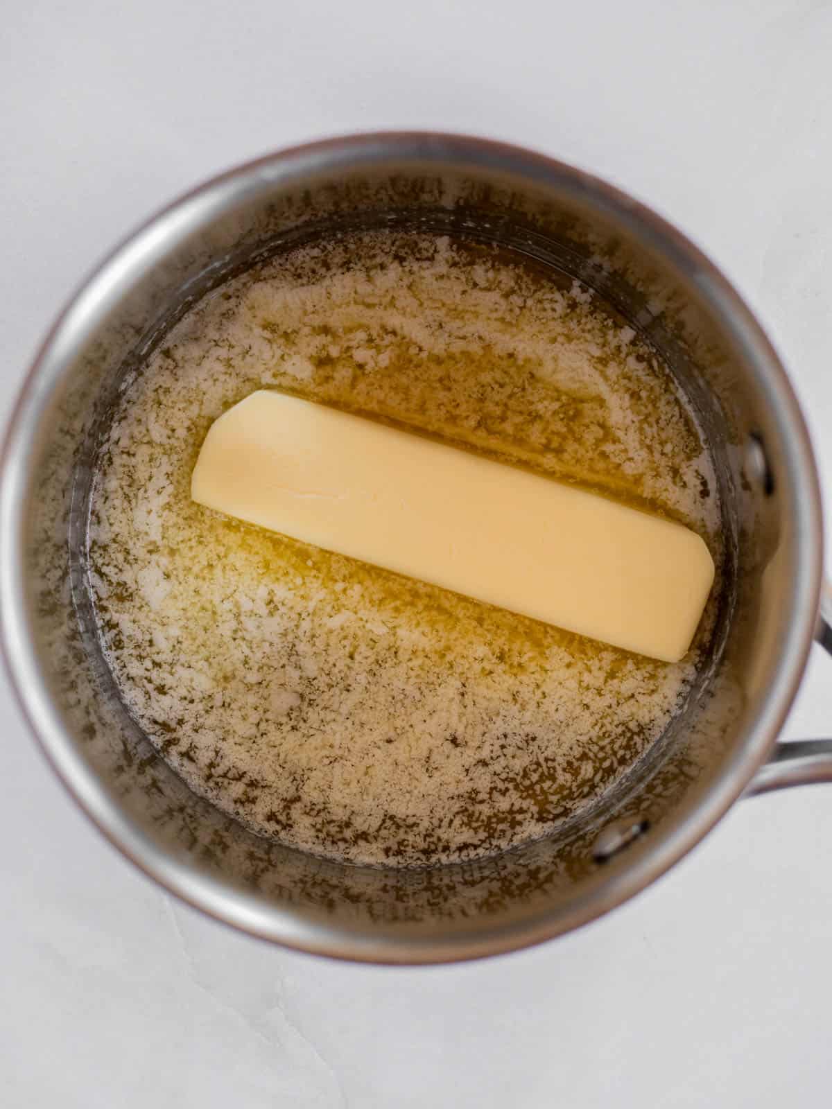 partially melted butter in a silver pot.