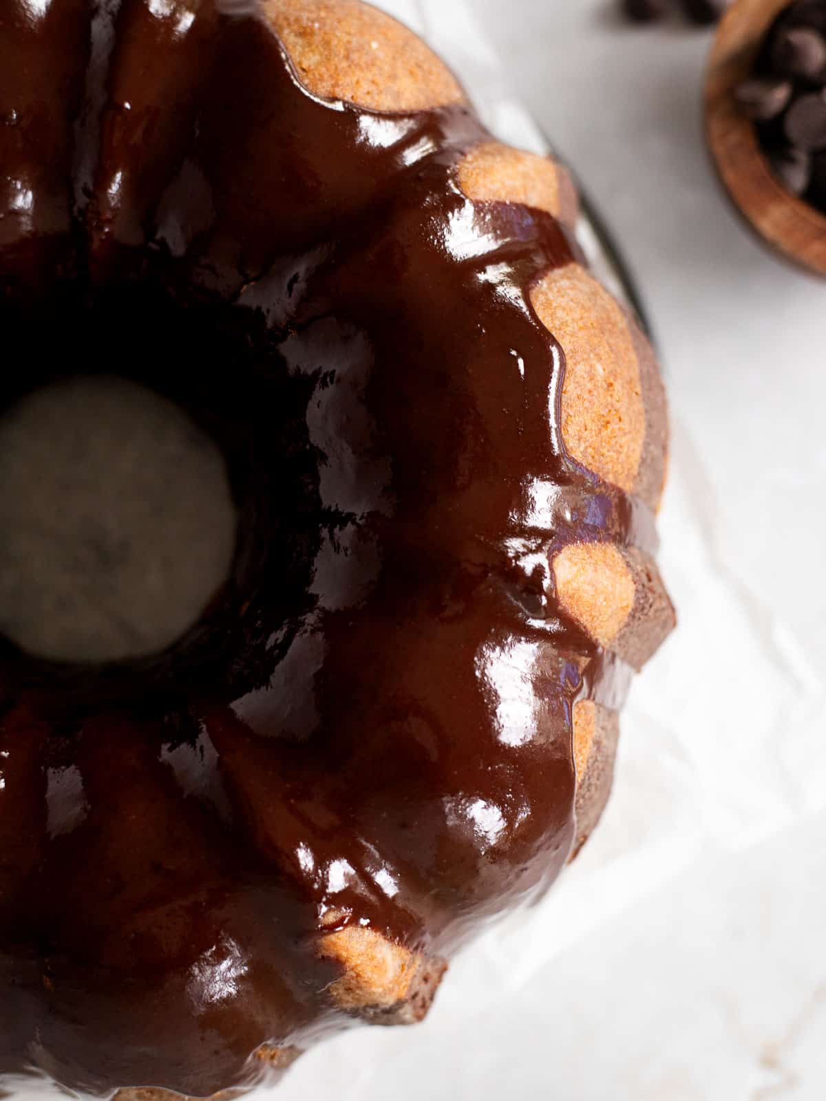 overhead photo of a chocolate and vanilla swirled bundt cake with a chocolate glaze.