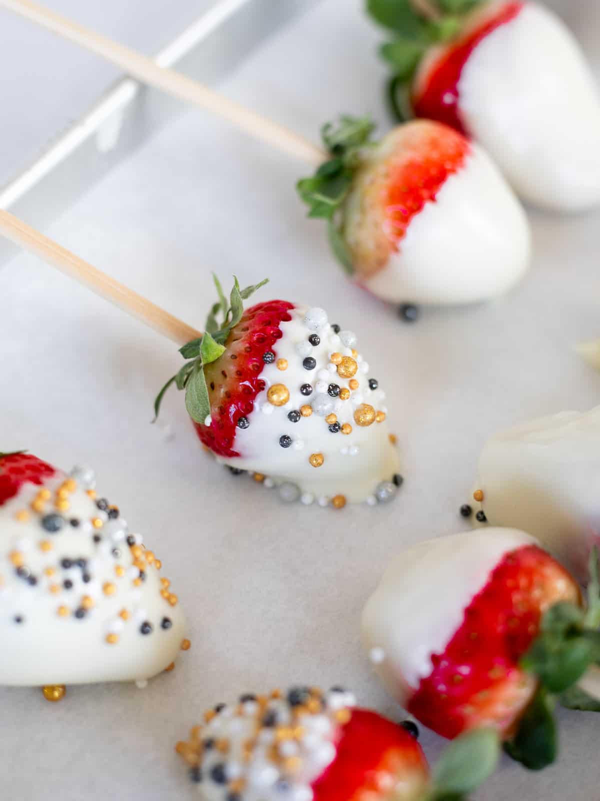 white chocolate strawberries decorated with sprinkles.