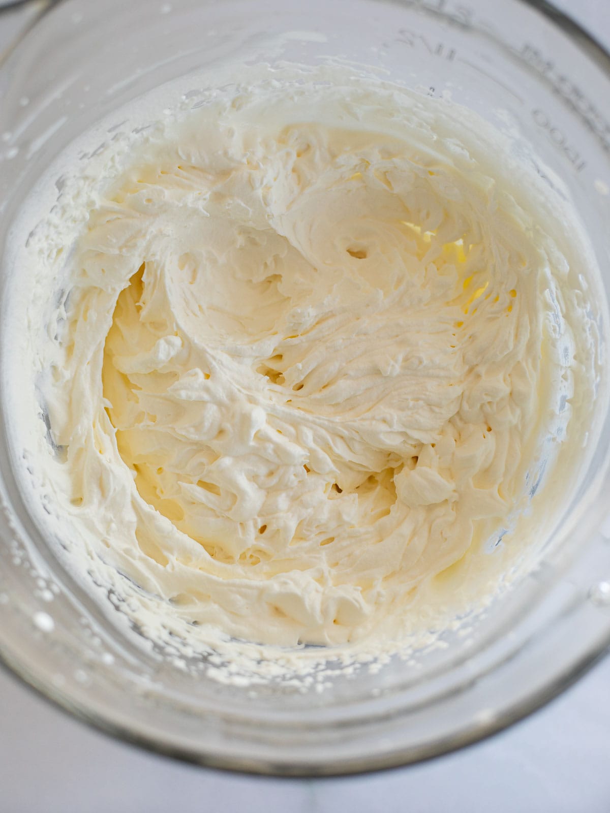heavy cream whipped to stiff peaks in a glass bowl.