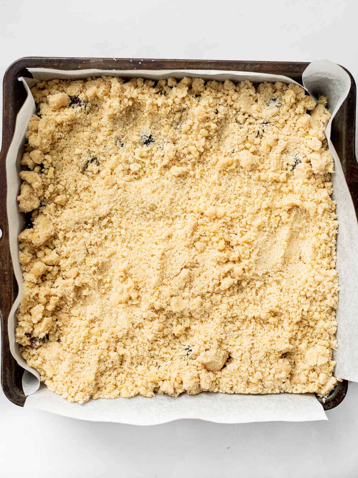 blueberry shortbread bars with crumb topping in a baking pan.