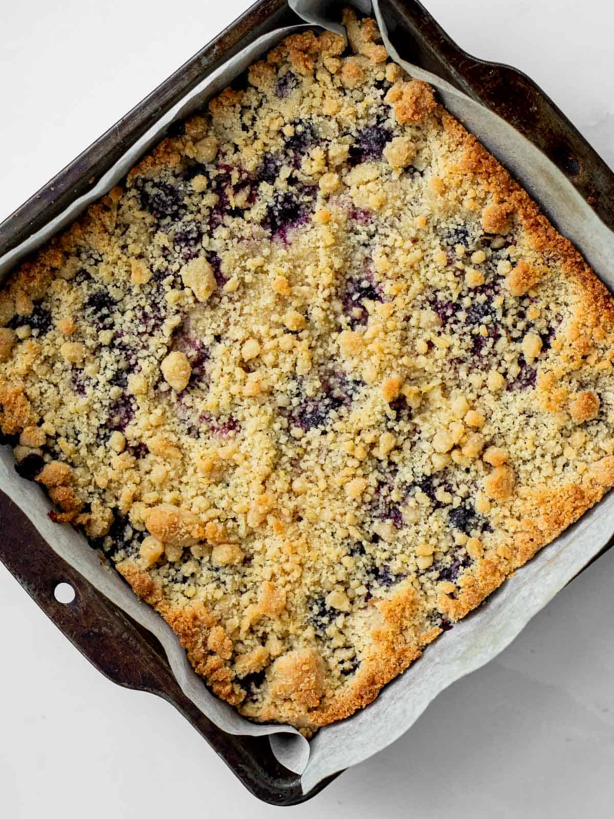 baked blueberry lemon shortbread in a parchment lined baking pan.