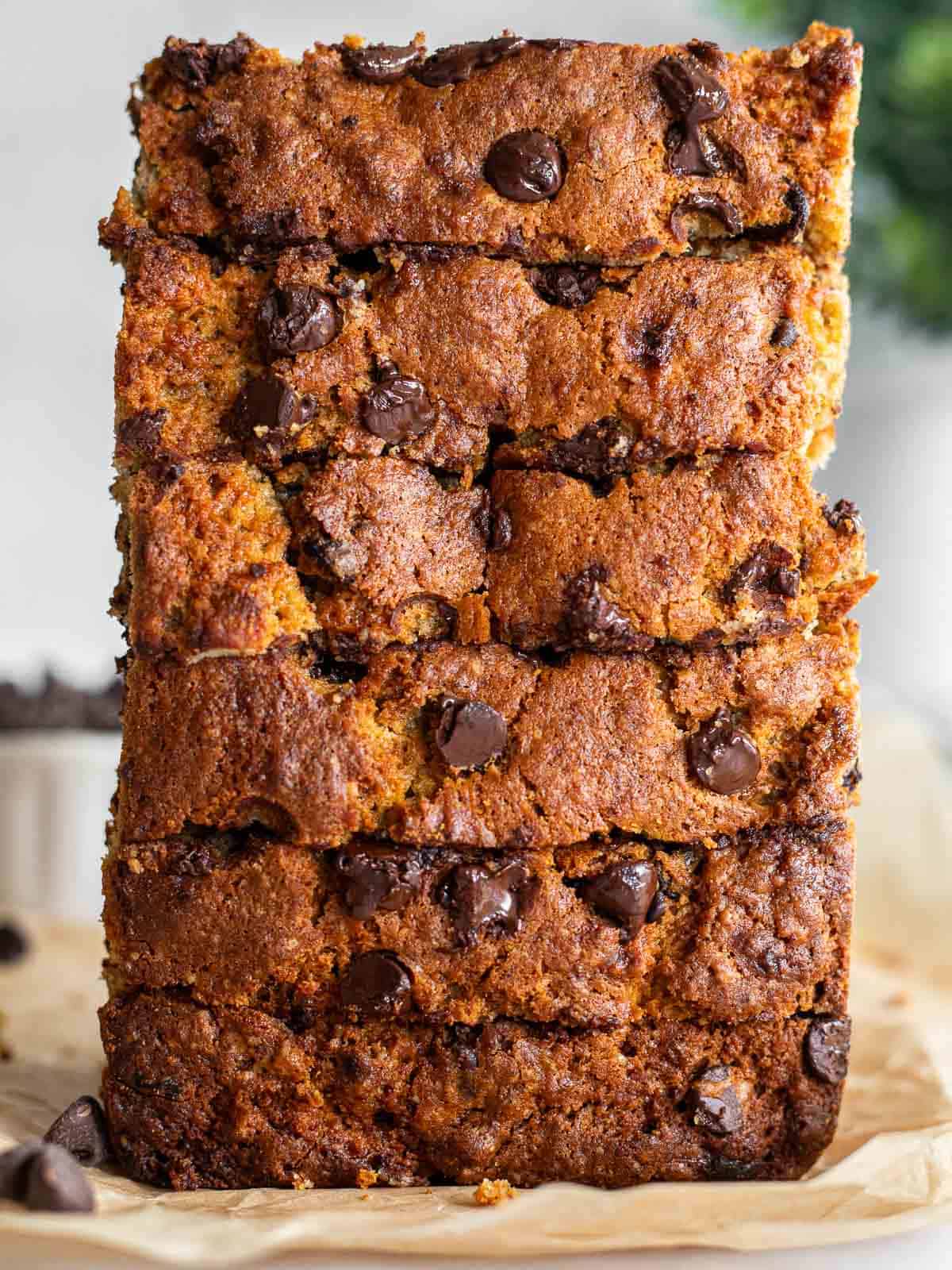 a loaf of brown butter banana bread with chocolate chips, sliced and stacked on it's end.
