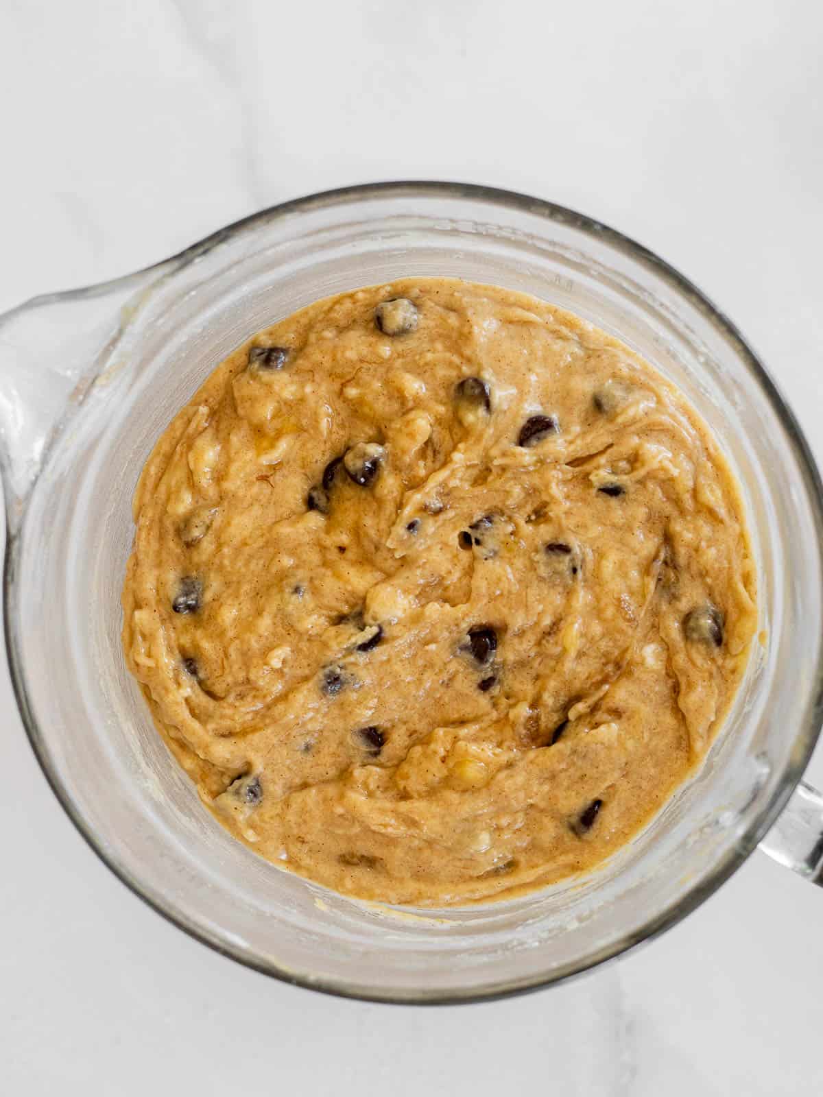 brown butter chocolate chip banana bread batter in a glass mixing bowl.